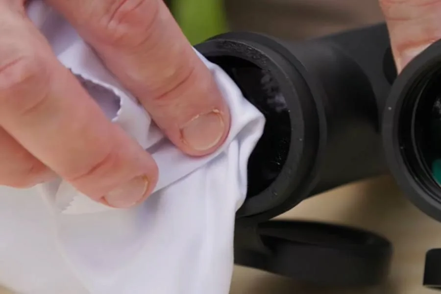 Polishing binocular lenses with an antistatic microfiber cloth